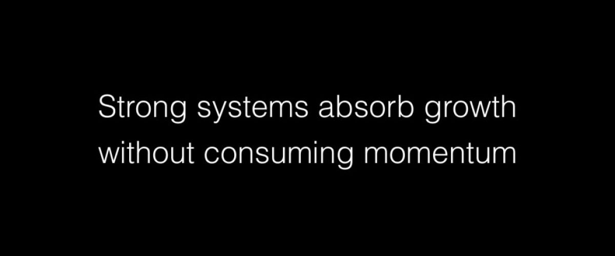 Strong systems absorb growth without consuming momentum